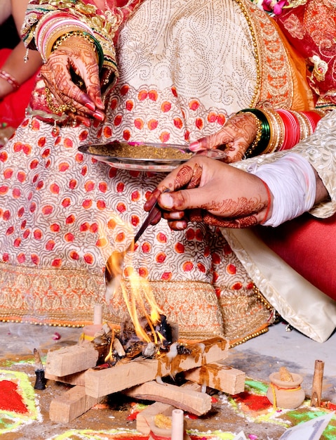 Close-up foto da noiva e do noivo realizando rituais religiosos