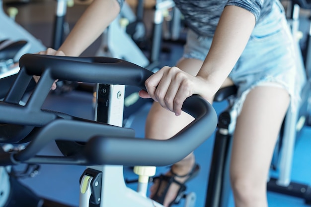 Close-up Frauen arbeiten in der Turnhalle auf dem Heimtrainer,