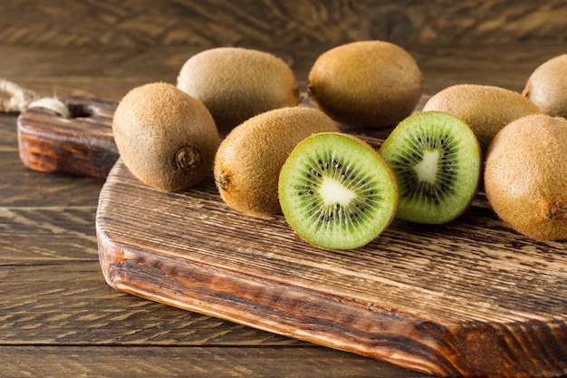 Foto close-up fresco kiwi maduro na mesa de madeira. saborosas frutas tropicais para uma alimentação e dieta saudável.
