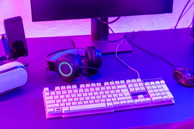 Close up gamer espacio de trabajo juego configurar equipos modernos en el escritorio equipo de juego ratón auriculares ordenador ratón listo para en línea