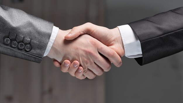 Close up.handshake von Geschäftspartnern auf dunklem Hintergrund.