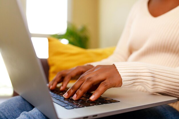 Close up handsof Afroamerikanerin Text auf Laptop-Tastatur eingeben