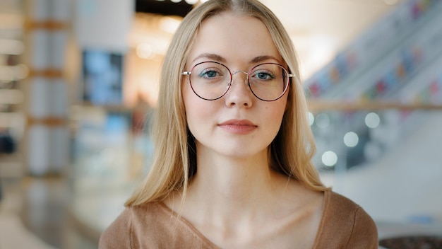 Close up Headshot Porträt drinnen ruhige kaukasische Frau in Brillen Dame Mädchen blonde Frau in Gläsern drinnen posiert Blick in die Kamera Geschäftsfrau Arbeiter Student Modell Unternehmen CEO Arbeitgeber Chef