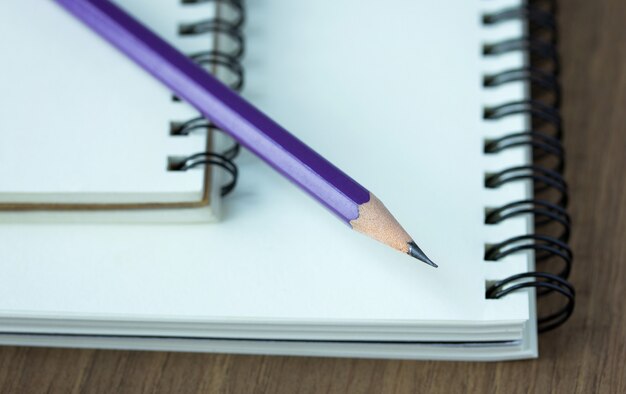 Close-up lápis e caderno espiral na mesa de madeira, ponto de foco seletivo
