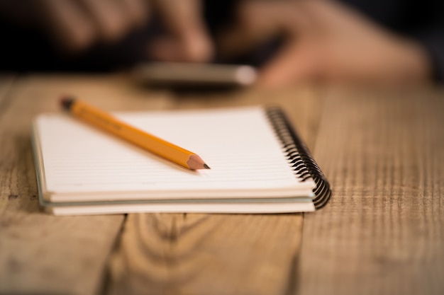 Foto close up en la mano de un hombre escribiendo en papel con un lápiz