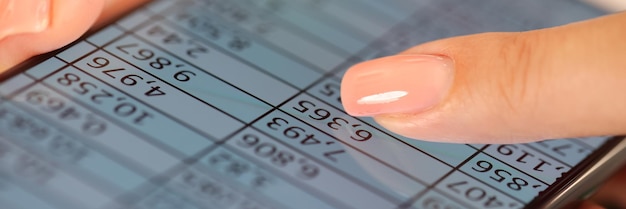 Close up de la mano de la mujer sosteniendo el teléfono móvil con datos financieros en la pantalla de la aplicación móvil