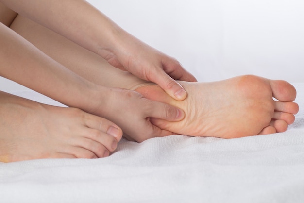 Close-up de manos femeninas haciendo masaje de pies