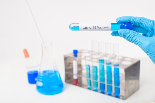 Close-up mão médico está segurando a vacina covid-19 em laboratório