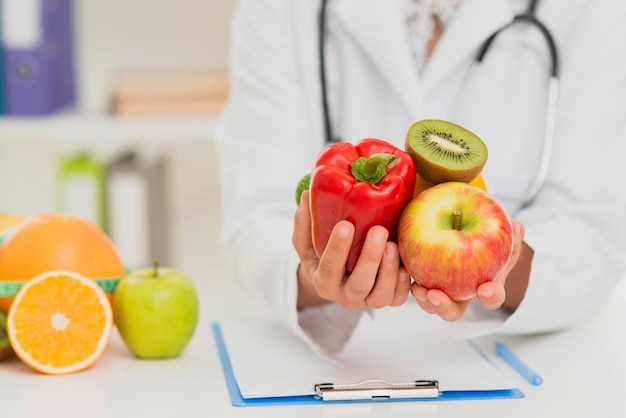 Foto close-up médico segurando frutas e legumes