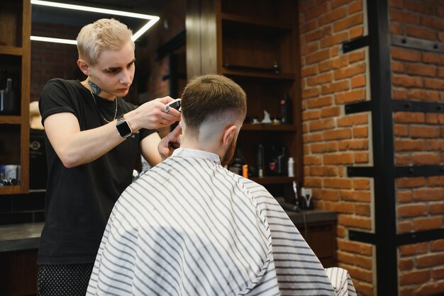 Close-up, mestre cabeleireiro faz penteado e estilo com tesoura e pente.