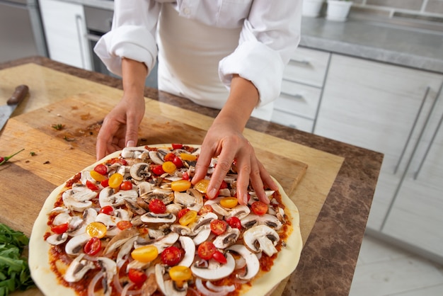 close-up mulher cozinhando pizza