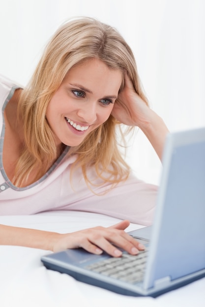 Close-up, Mulher usando seu laptop, olhando a tela e sorrindo