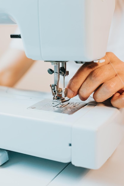 Close-up mulher usando uma máquina de costura costura reutiliza tecido de roupas jeans velhas Reutiliza tecidos velhos para sustentabilidade de roupas novas Velhos novo hobby em casa idosos atividade mental e trabalho