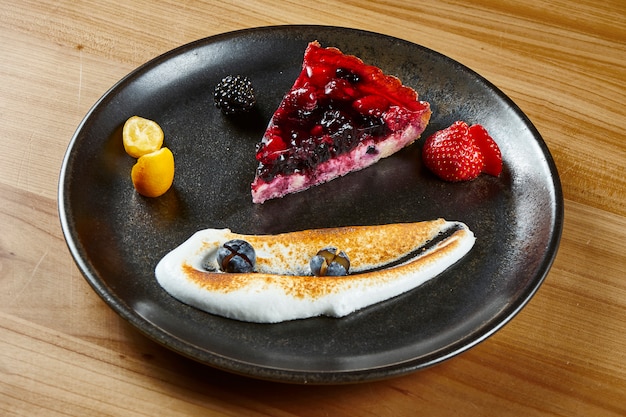 Close-up na fatia saborosa de Berry Airy delicado Cheesecake no prato escuro