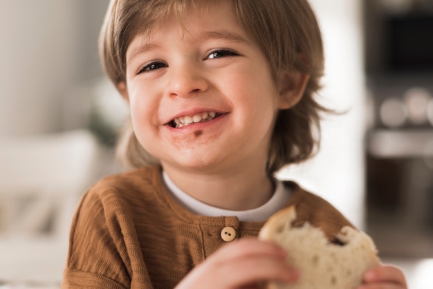 Close-up niño feliz comiendo sandwich