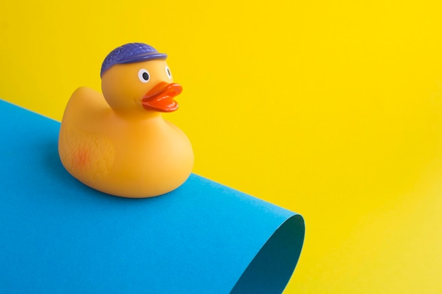 Close-up no patinho de brinquedo amarelo para tomar banho no fundo colorido. Copie o espaço.