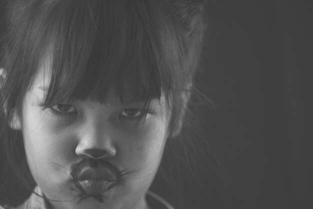 Close-up-Porträt eines Mädchens mit Gesichtsfarbe, die die Lippen gegen die Wand zerknirscht