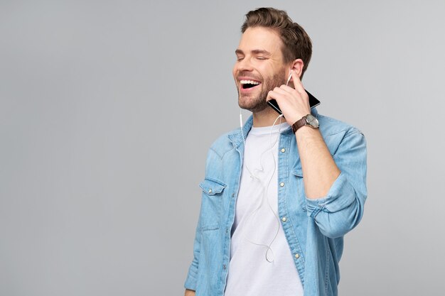 Close Up retrato de alegre joven disfrutando de escuchar música vistiendo ropa casual de jeans