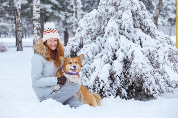 Close-up retrato cão corgi fofo e seu dono brincando em uma caminhada de inverno ao ar livre