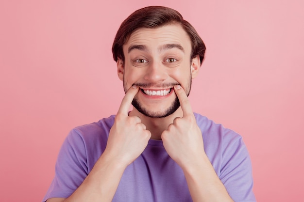 Foto close up retrato de chico positivo feliz positivo indicar dedos dentudos sonrisa cuidado bucal aislado sobre fondo de color rosa