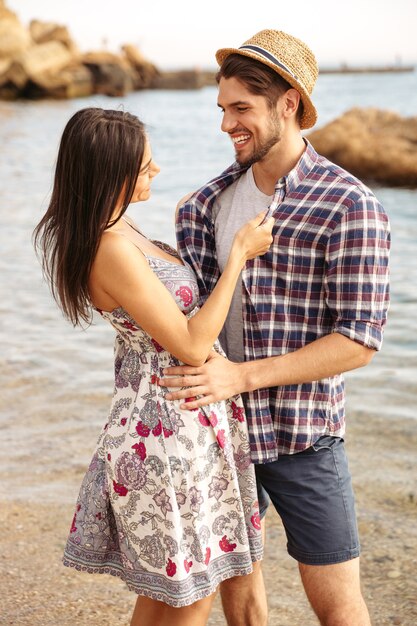 Close Up retrato de una feliz pareja joven inconformista en el amor de pie en la playa y abrazar