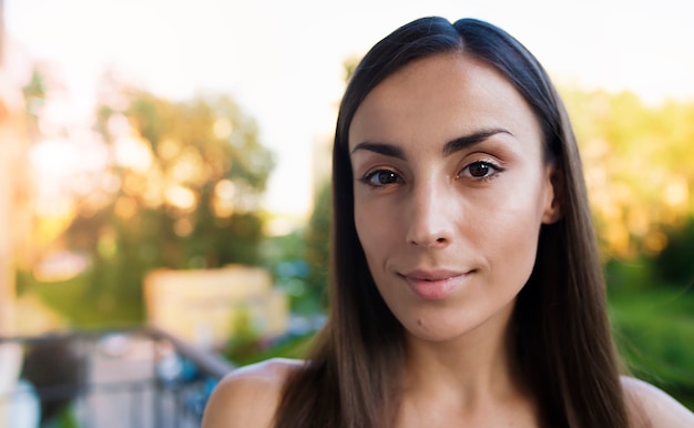 Close Up retrato de una joven hermosa mujer morena con piel limpia y mirada tranquila