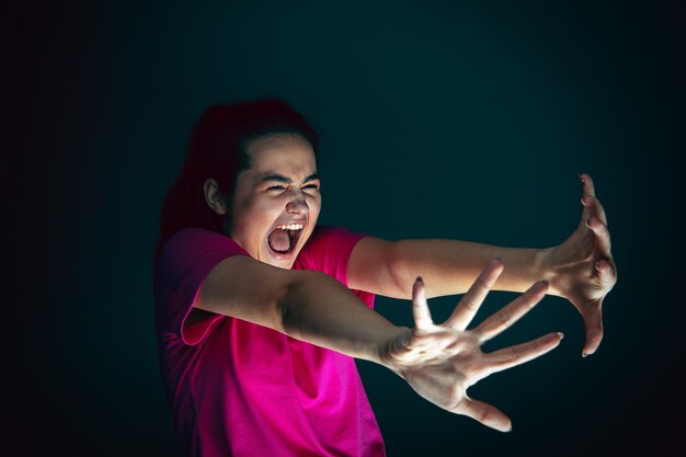 Close Up retrato de joven loca asustada y conmocionada aislada sobre fondo oscuro