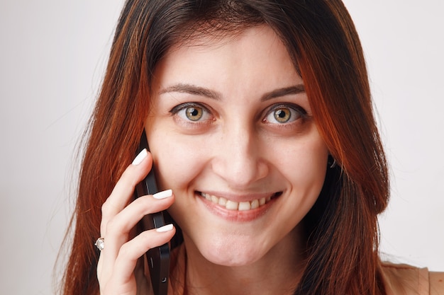 Close Up retrato de una joven morena hablando por su teléfono móvil