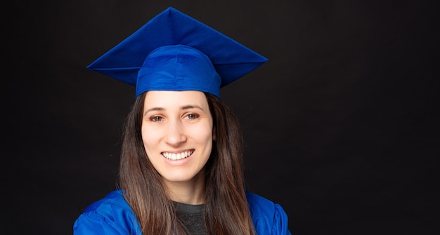 Foto close up retrato de mujer joven estudiante alegre vistiendo gorro de graduación