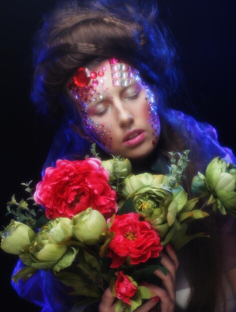 Close Up retrato de mujer joven en imagen creativa con flores grandes