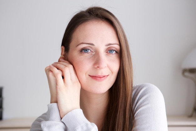 Foto close up retrato de una mujer joven con el pelo largo sonriendo y mirando