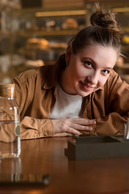 Close Up retrato de mujer joven sentada en la cafetería y mirando a la cámara