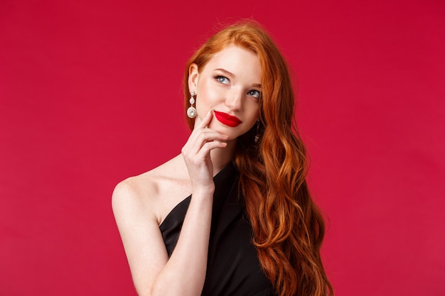 Foto close-up retrato de mujer soñadora elegante y con estilo pelirroja en vestido negro