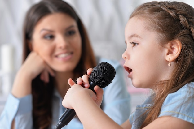 Close Up retrato de niña con madre cantando