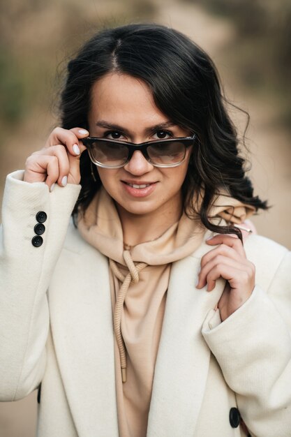 Close Up retrato de niña morena con gafas de sol en el bosque