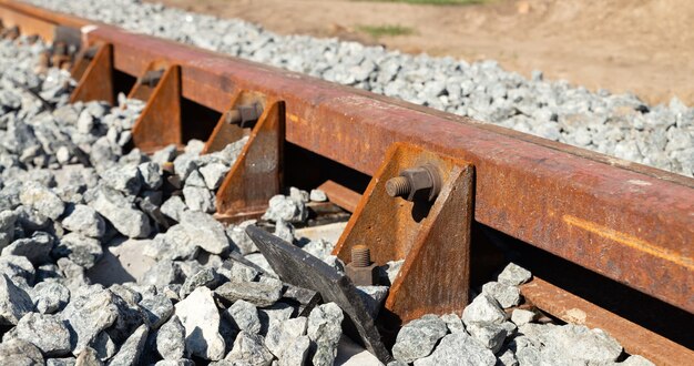 Close-up de un riel de ferrocarril en escombros