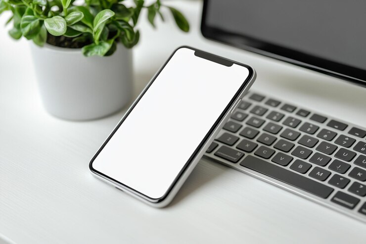 Foto close-up smartphone und computer auf weißem tischtop view weißer bildschirm-mockup
