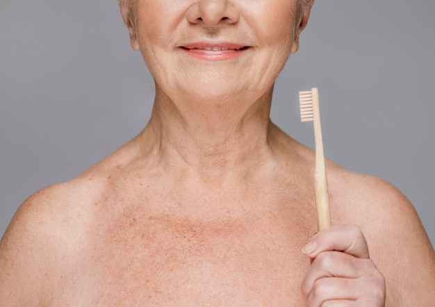 Foto close-up sonriente mujer sosteniendo cepillo de dientes