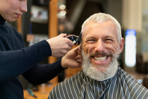 Foto close-up sorridente homem cortando o cabelo