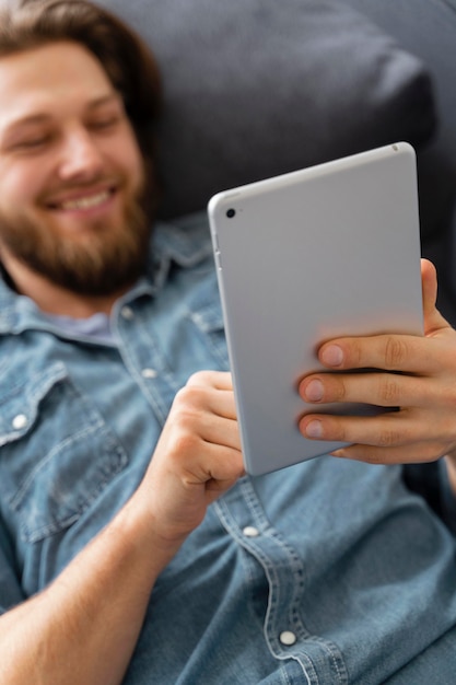 Foto close-up sorridente homem segurando o tablet