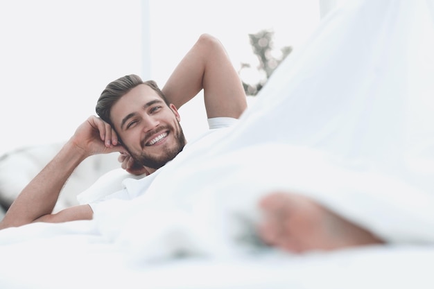 Close-up sorrindo; homem descansando no quarto