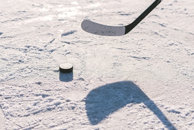 Close-up-Stick und Puck auf dem Eishintergrund