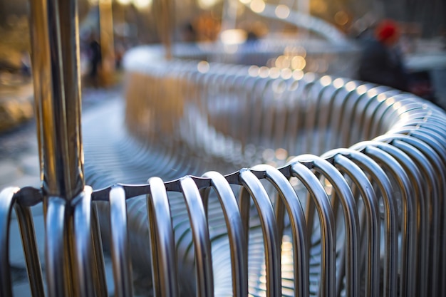 Close-up-Straßenbank-Metallrohre, die auf einer Straßenstruktur parallel zueinander angeordnet sind. Konzept für wetterbeständige Materialien und modernes Industriedesign. Platz für Werbung