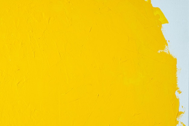 Close-up textura pintura de cor amarela sobre tela de cor branca marcas de pincel fundo de traçado