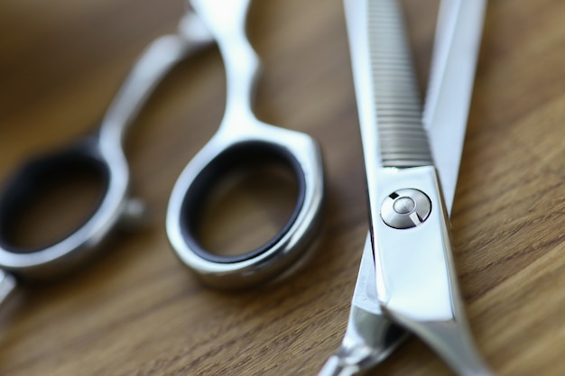 Foto close-up, tijeras de peluquero de acero están tumbados en la mesa