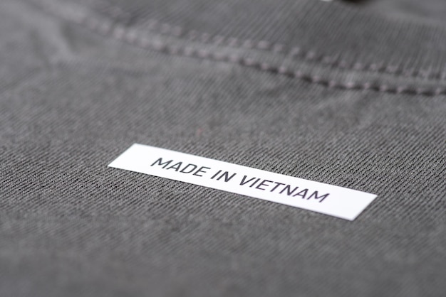 Close-up tiro da inscrição Made in Vietnam em TShirt cinza escuro Conceito de produção de roupas na Ásia, fabricação de negócios têxteis