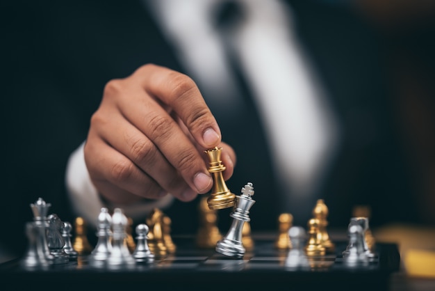 Foto close-up tiro xadrez dourado para derrotar a matar o rei de prata xadrez no tabuleiro de xadrez branco e preto para o conceito de vencedor e perdedor da competição de desafio de negócios