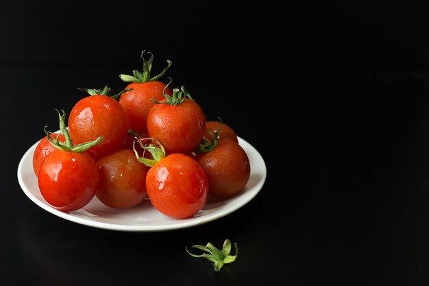 close-up tomate fresco em fundo preto tabela