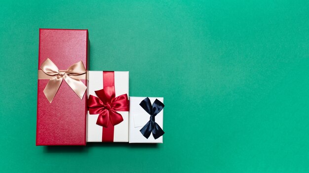 Close-up de tres cajas de regalo en superficie verde con espacio de copia