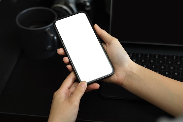 Close-up, uma fêmea de mãos segurando a maquete de tela em branco do smartphone para exibir seu banner gráfico.